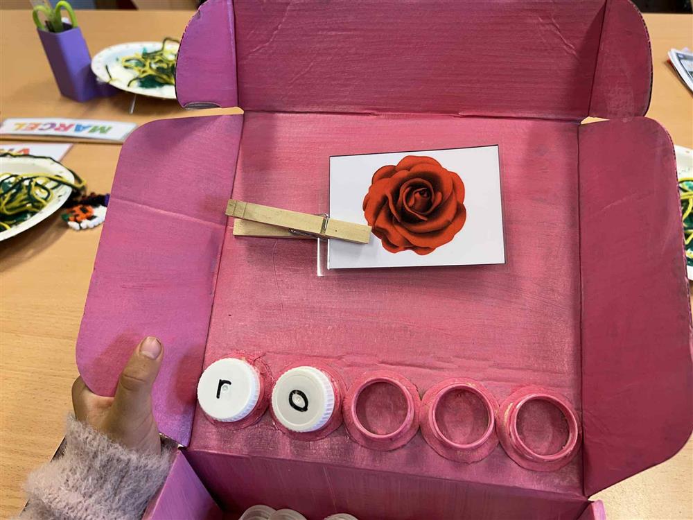 Bilde viser den rosa kriveboksen, ei rose og mange bokstavar - Klikk for stort bilete
