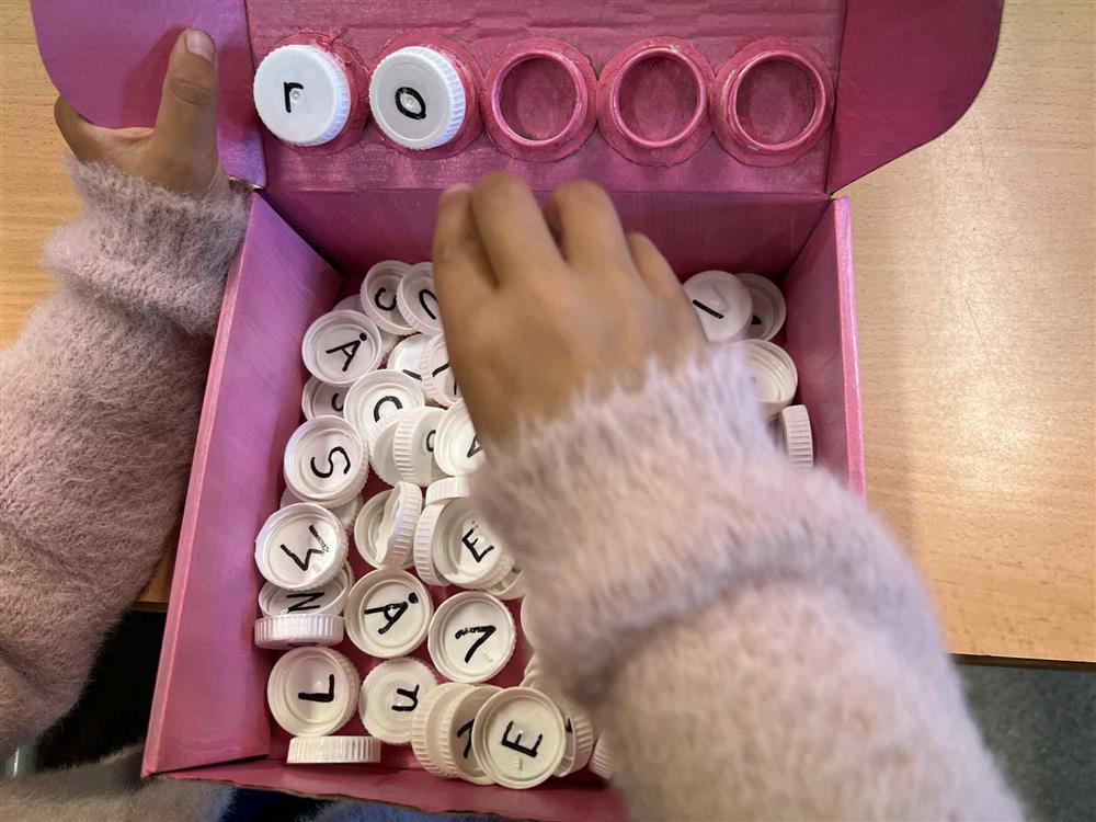 Bilde viser den rosa kriveboksen, ei rose og mange bokstavar - Klikk for stort bilete