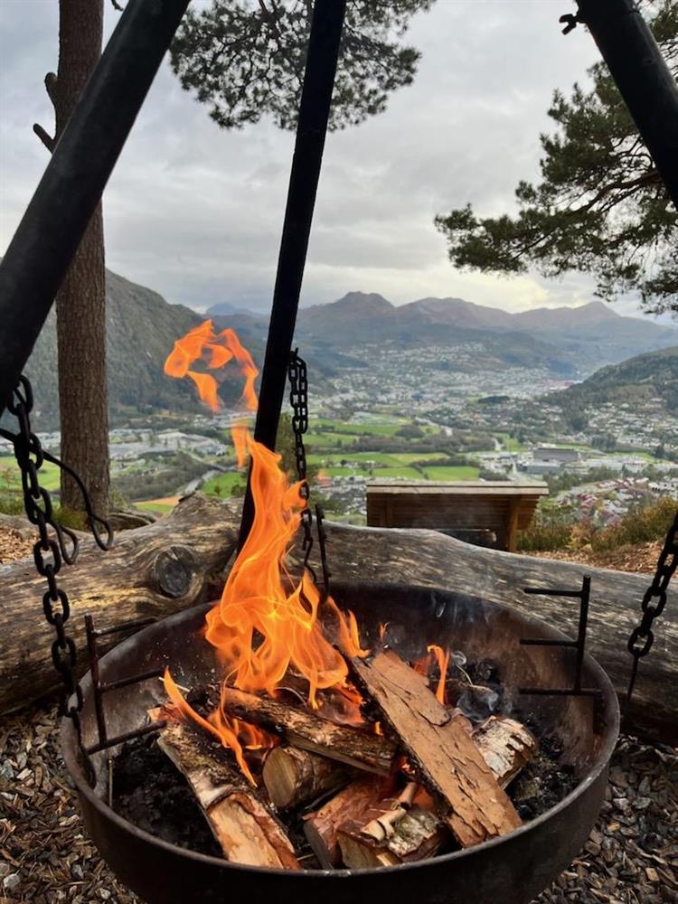 Flammar i bålpanna med førde by i bakgrunnen - Klikk for stort bilete