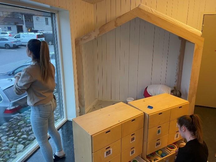 Ein person ryddar i kommoden mens den andre står og ser ut av vindauge - Klikk for stort bilete